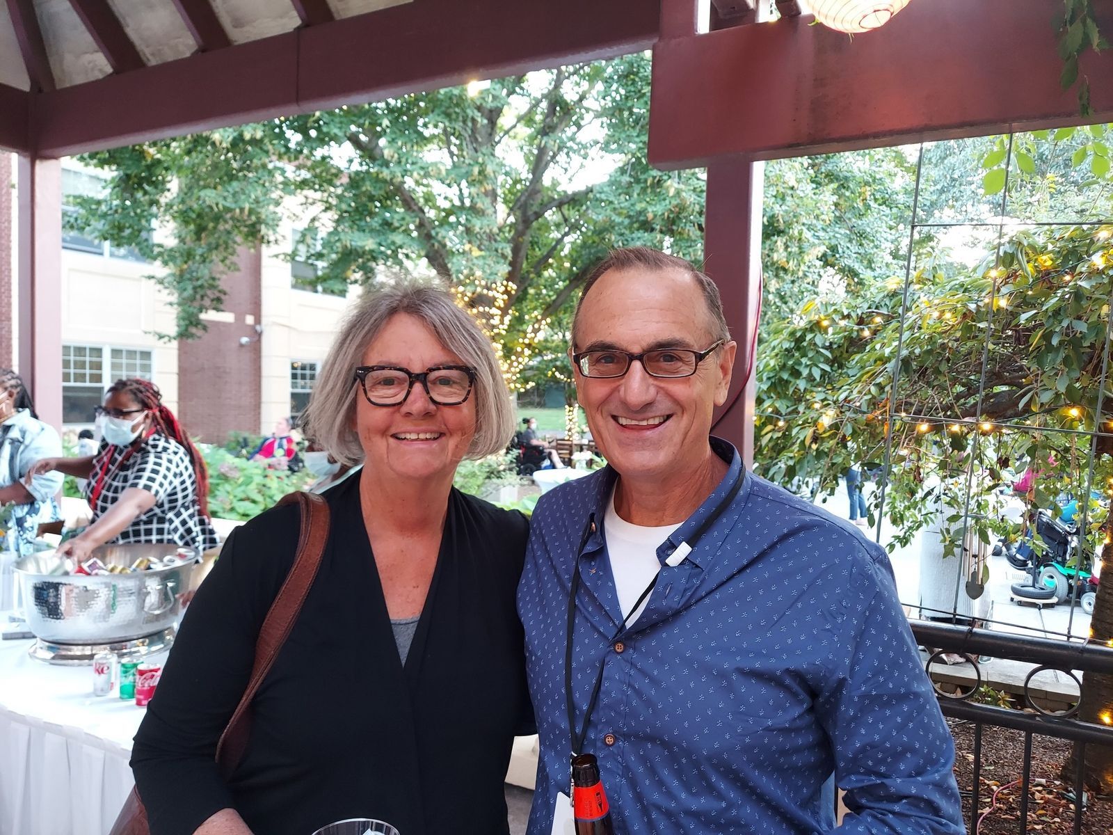 Two smiling people enjoying an outdoor event.