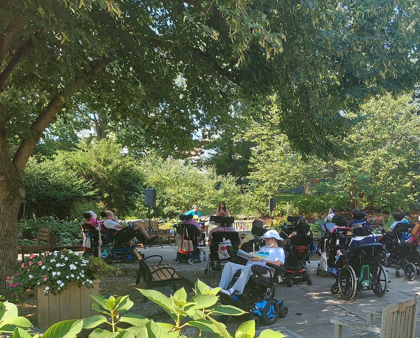 Residents enjoying a garden space in wheelchairs.