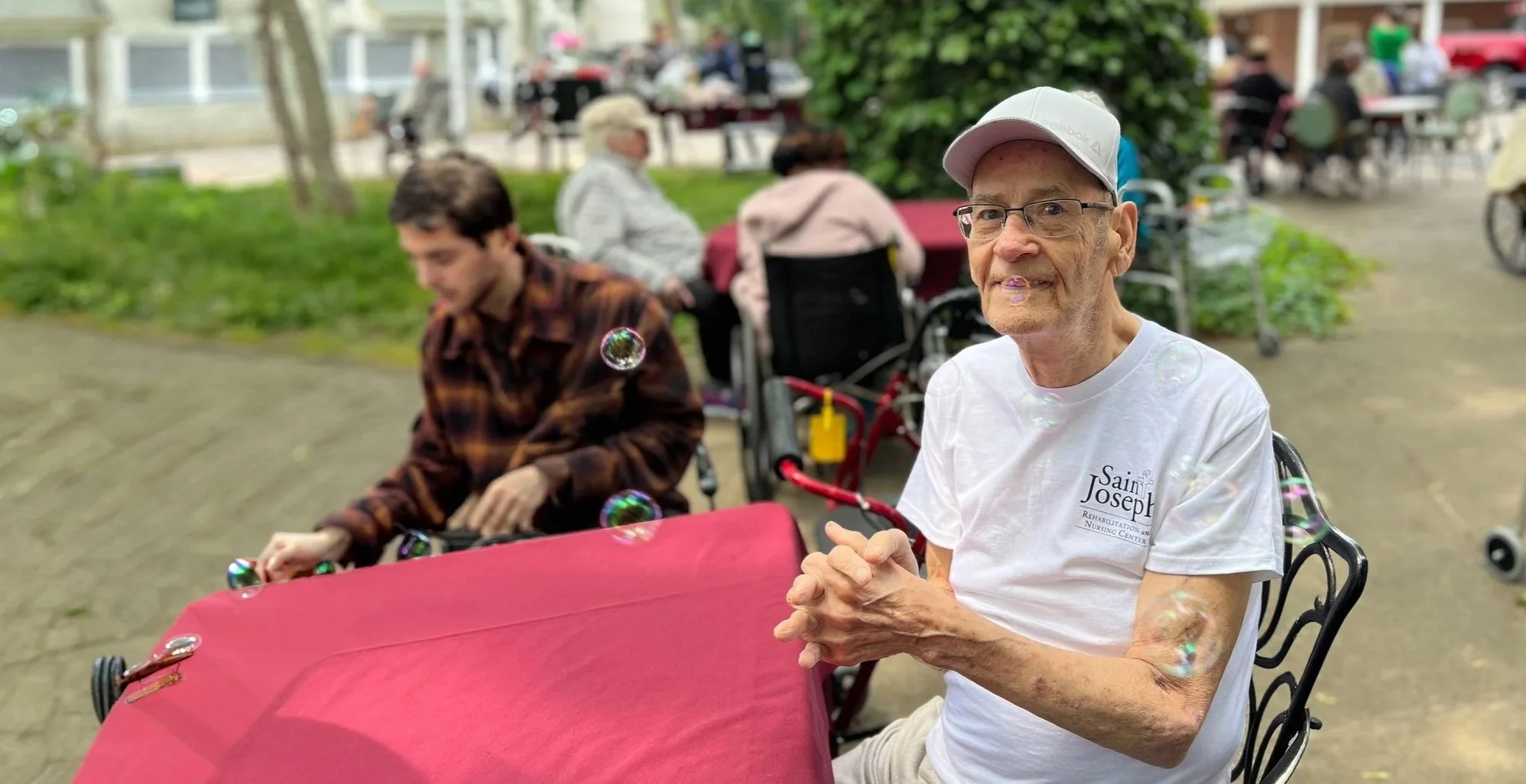 Older adult enjoys bubble activity outdoors.