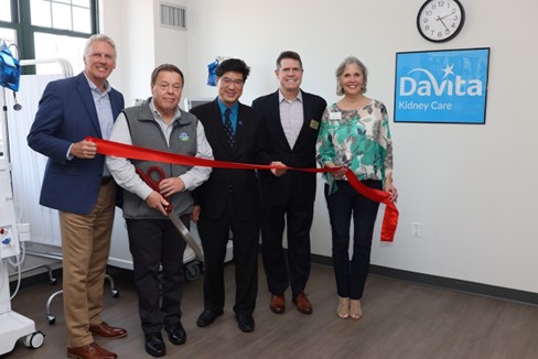 Ribbon-cutting ceremony in a facility room with people