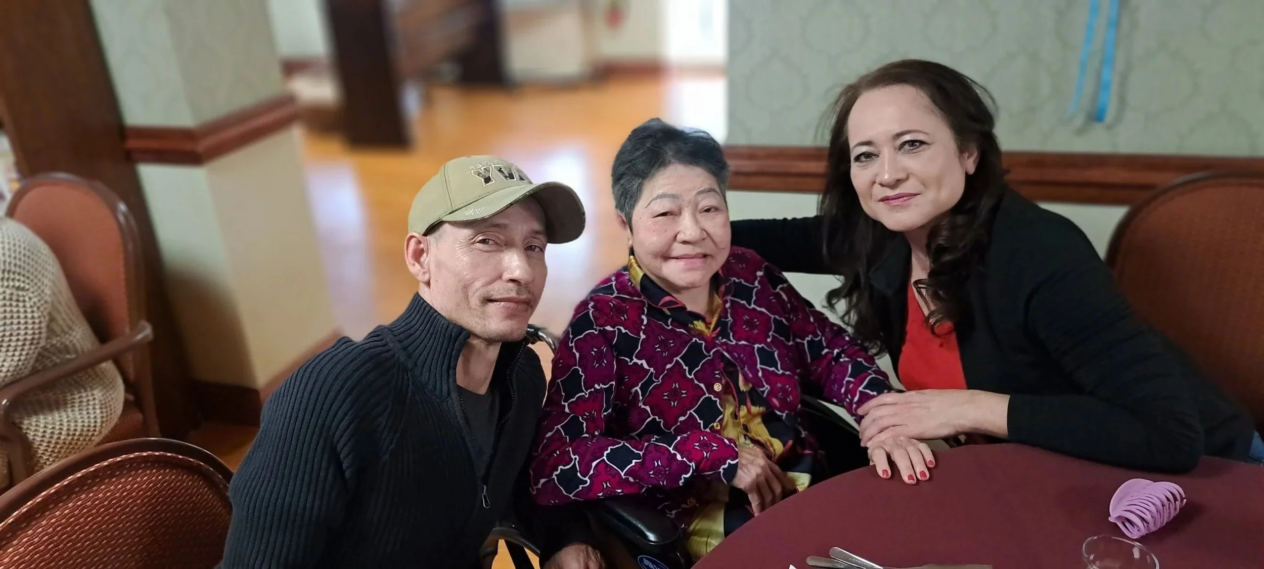 Three people smiling together in a common area