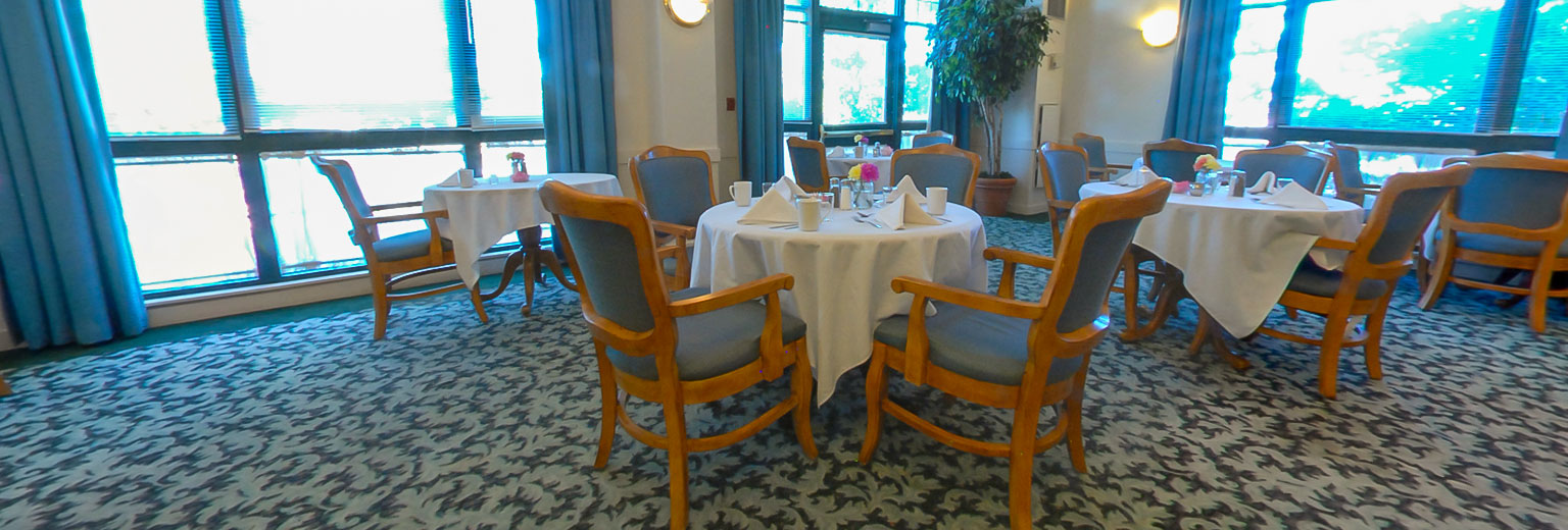 Dining area with tables and chairs arranged neatly.