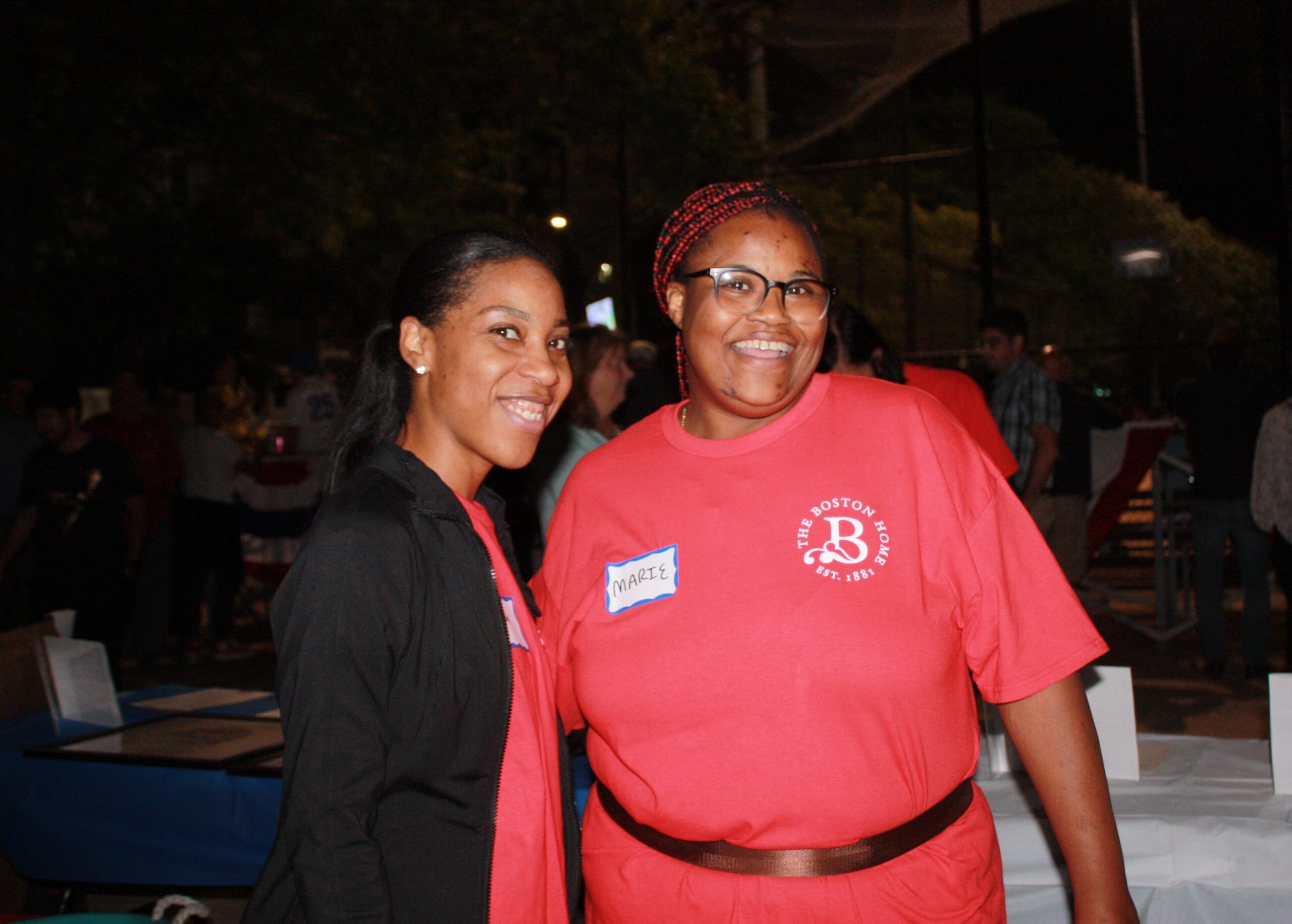 Two staff members smiling at a community event.