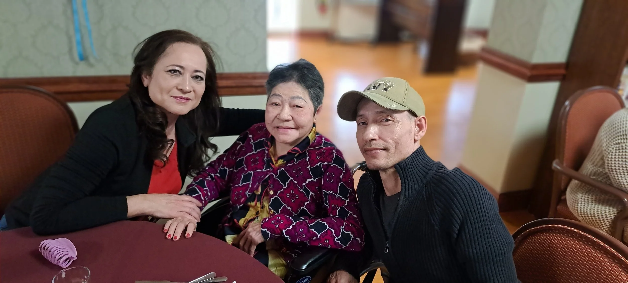 Three people smiling in a dining area