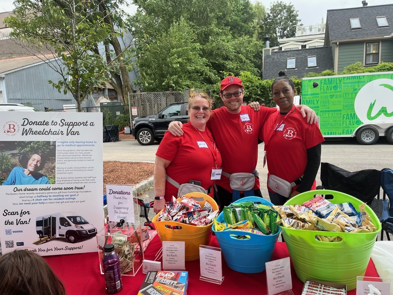 Three volunteers at an outdoor event with donation baskets.