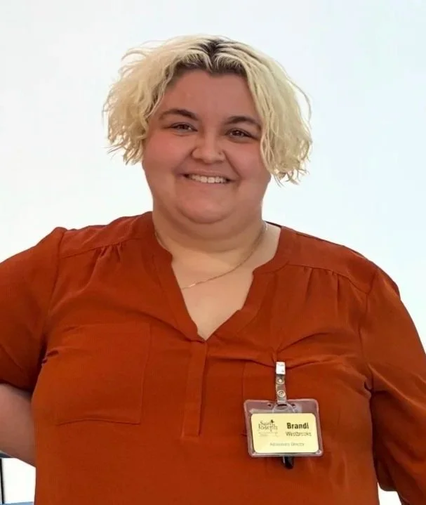 A staff member smiling with a name badge