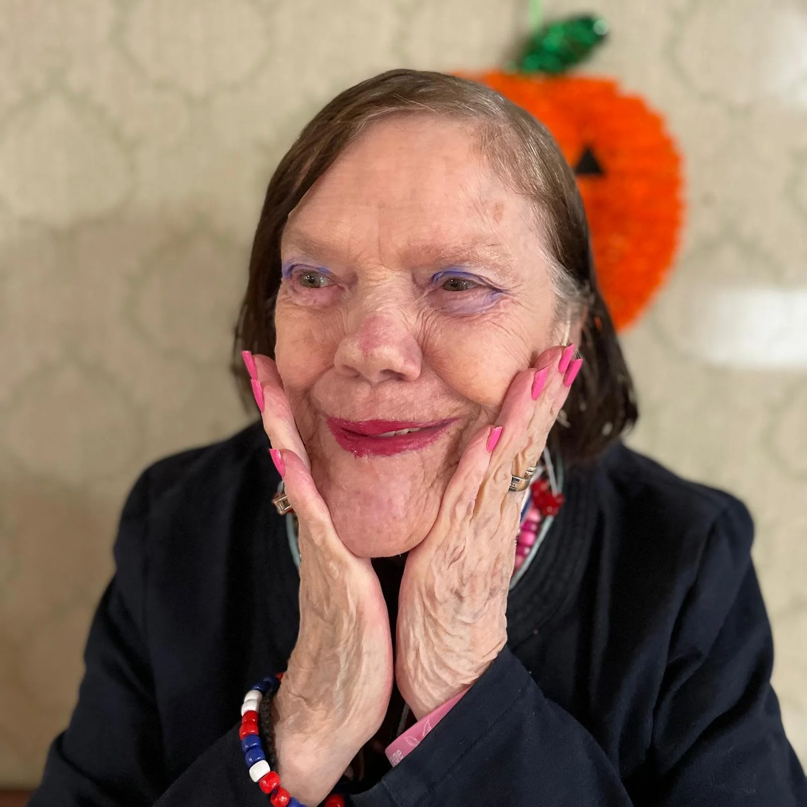 Senior woman smiling with hands on her face