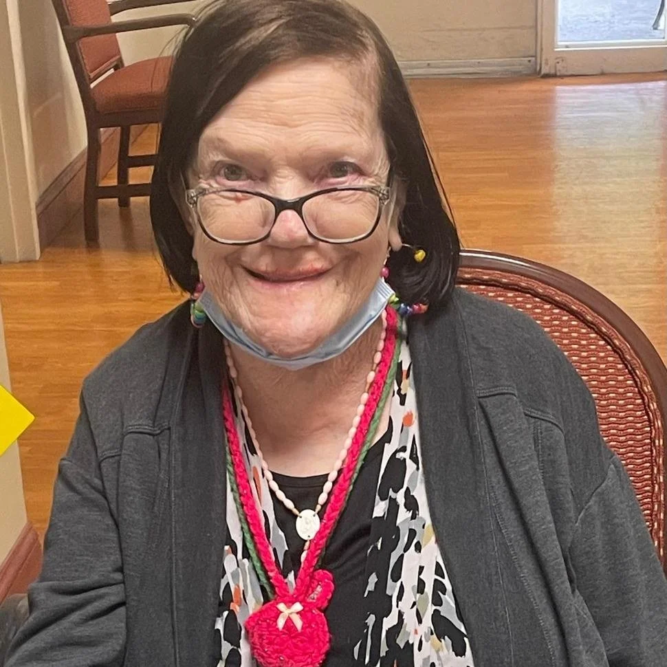 Smiling resident wearing colorful accessories.
