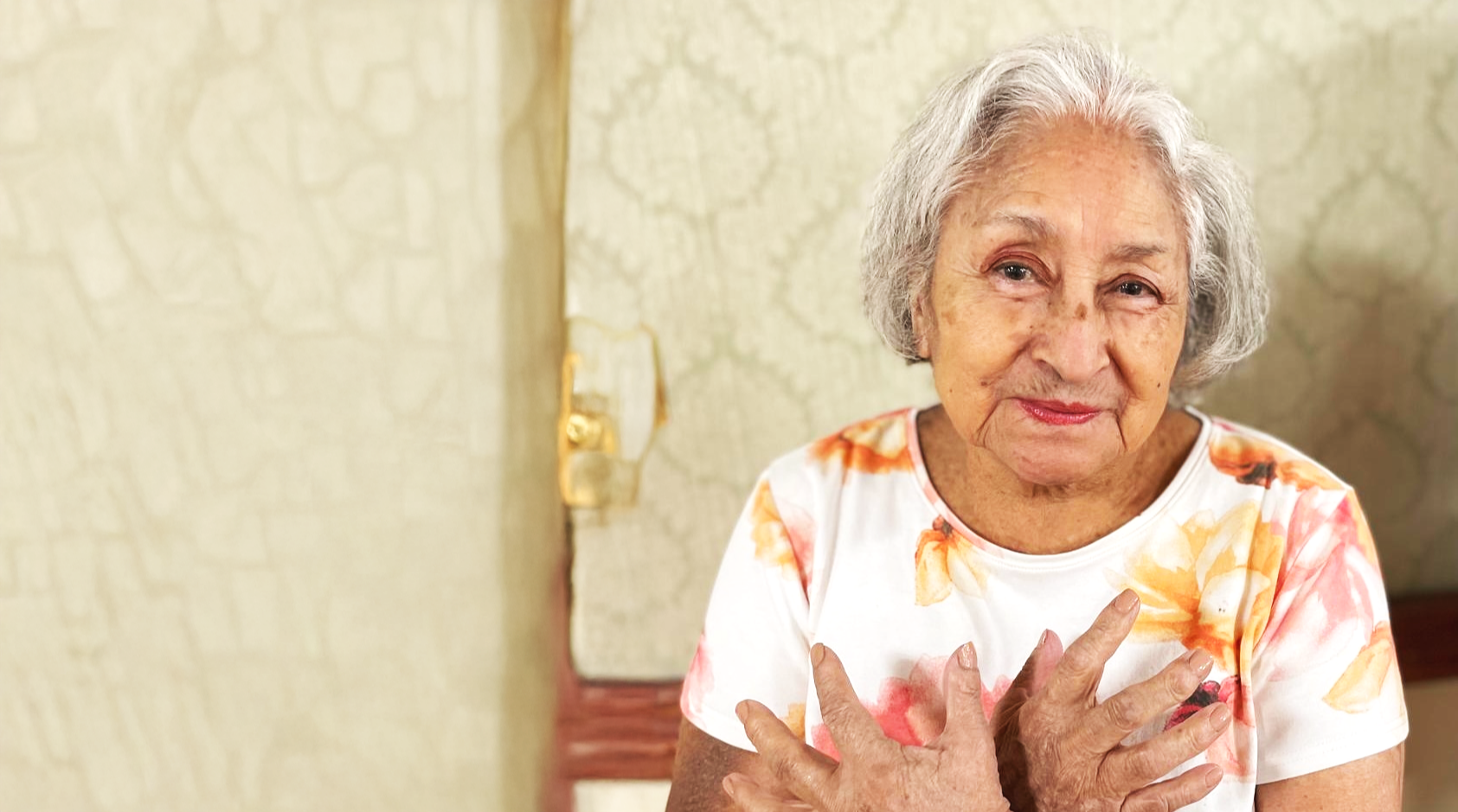 Smiling elderly woman with a floral shirt