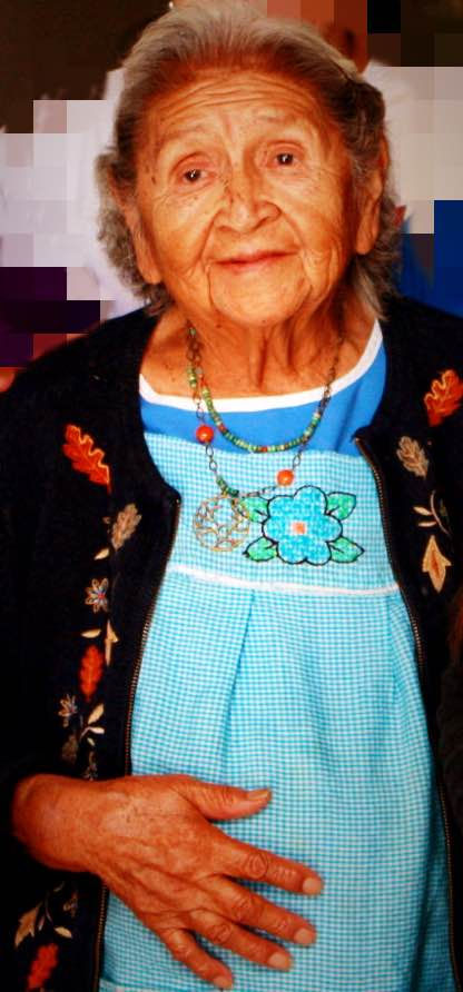 Senior woman smiling wearing a traditional outfit.