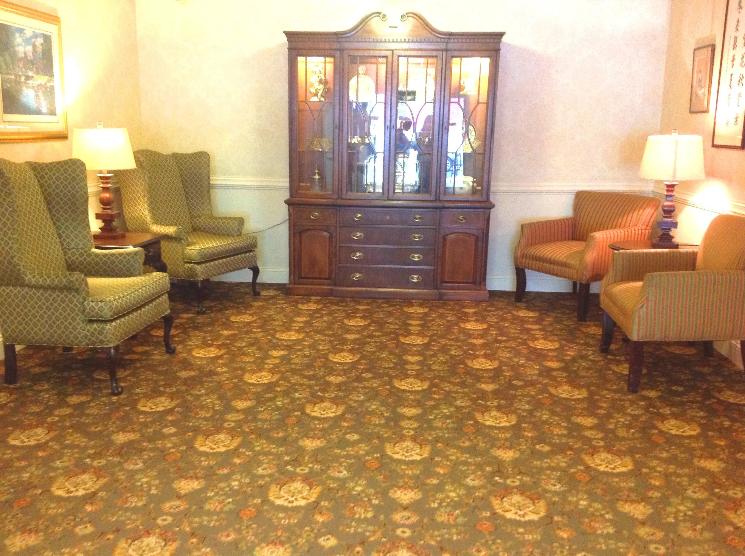 Common area seating with decorative cabinet and lamps