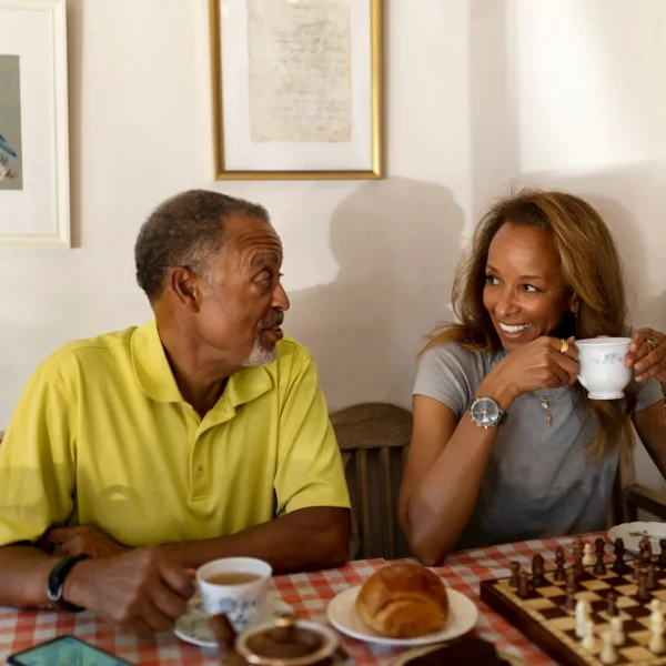 Two residents enjoying tea and a chess game.