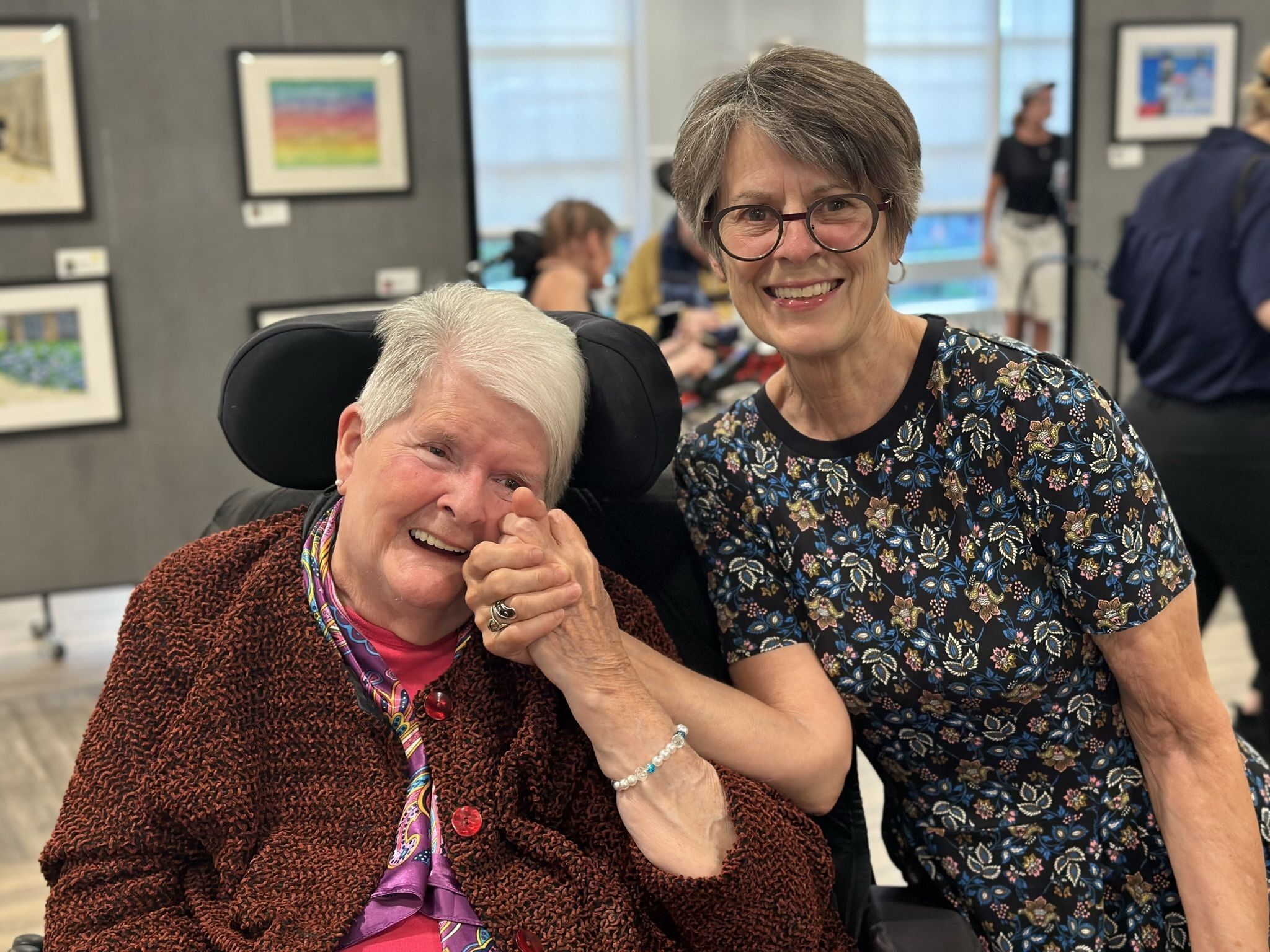Smiling resident and staff member in a common area.