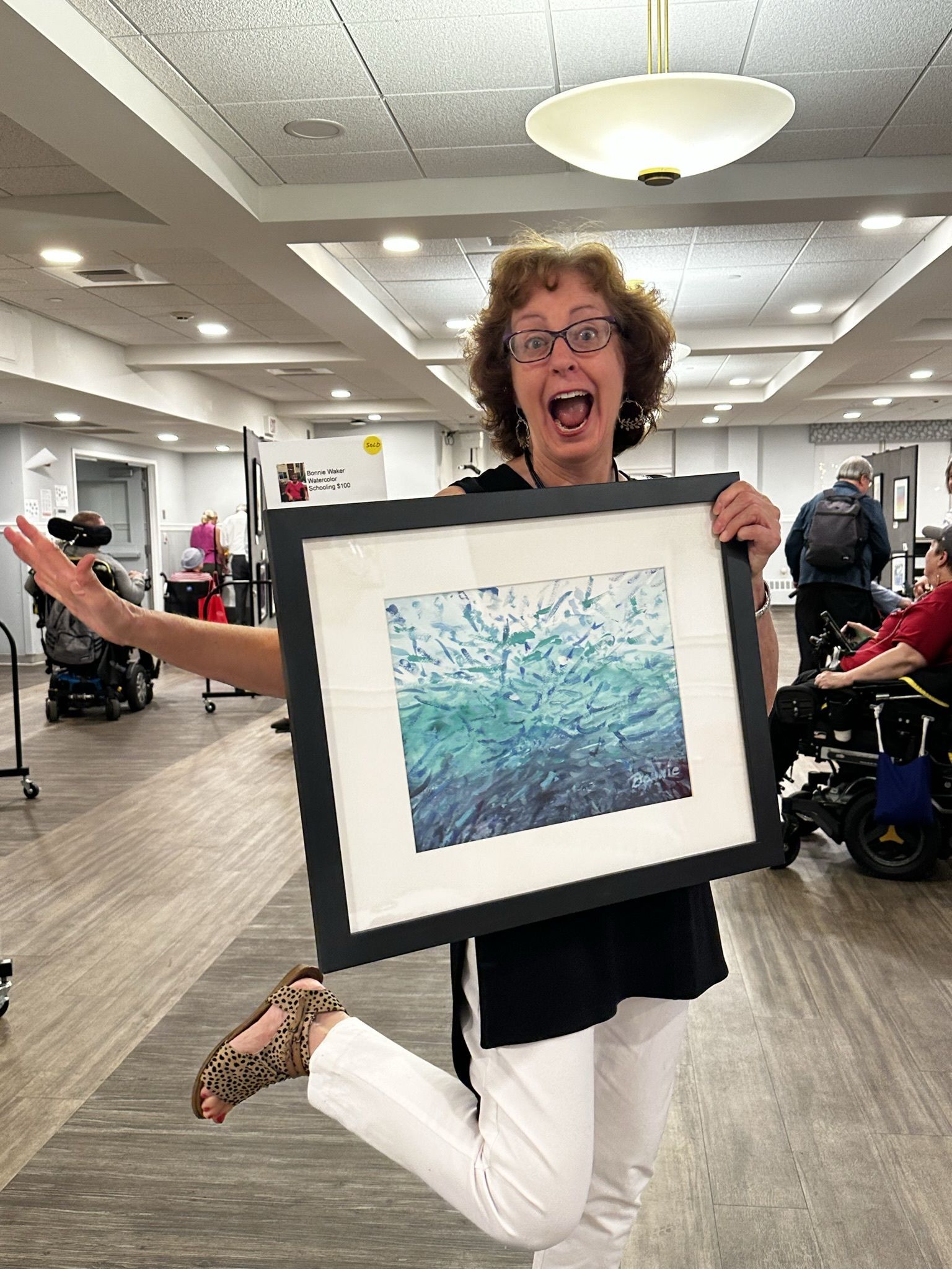 Staff member celebrating with artwork in a common area