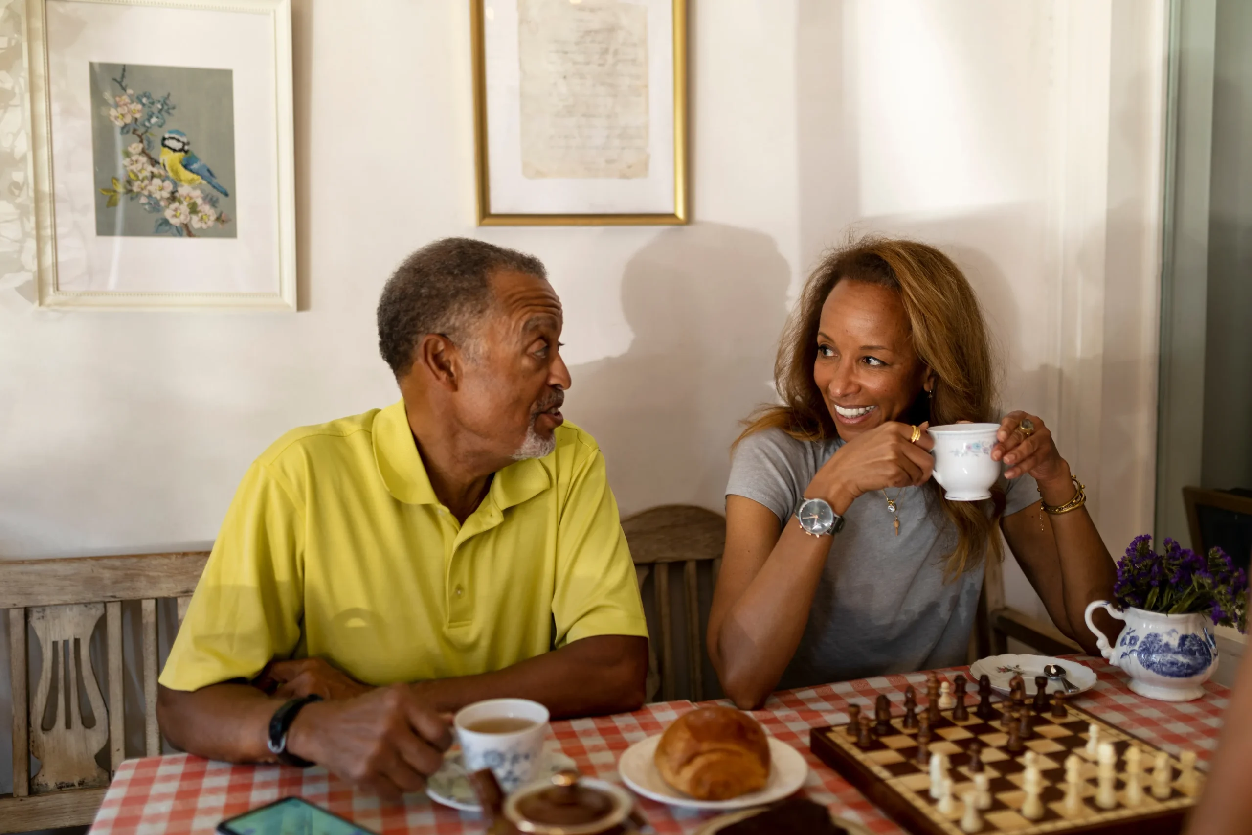 Two seniors engaged in conversation over refreshments