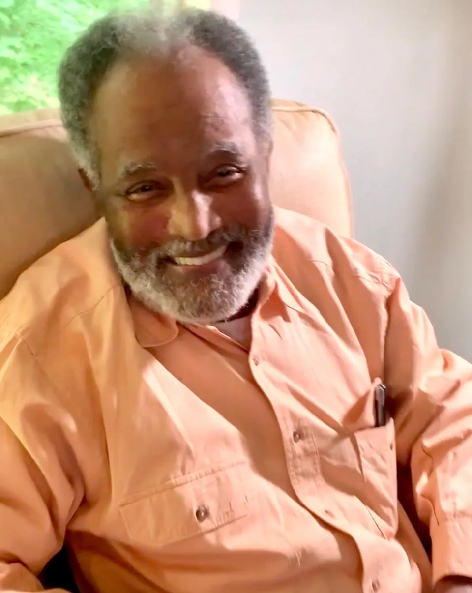 Resident smiling in a cozy seating area.