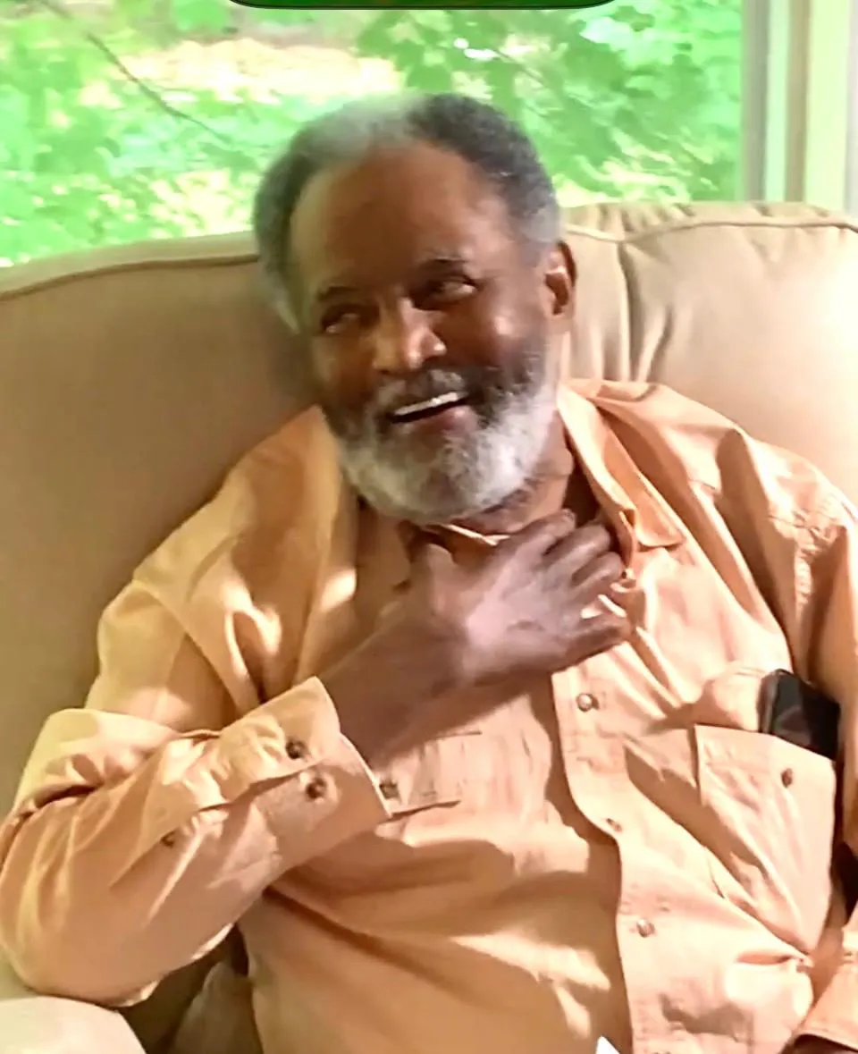 Elderly man laughing in a cozy chair