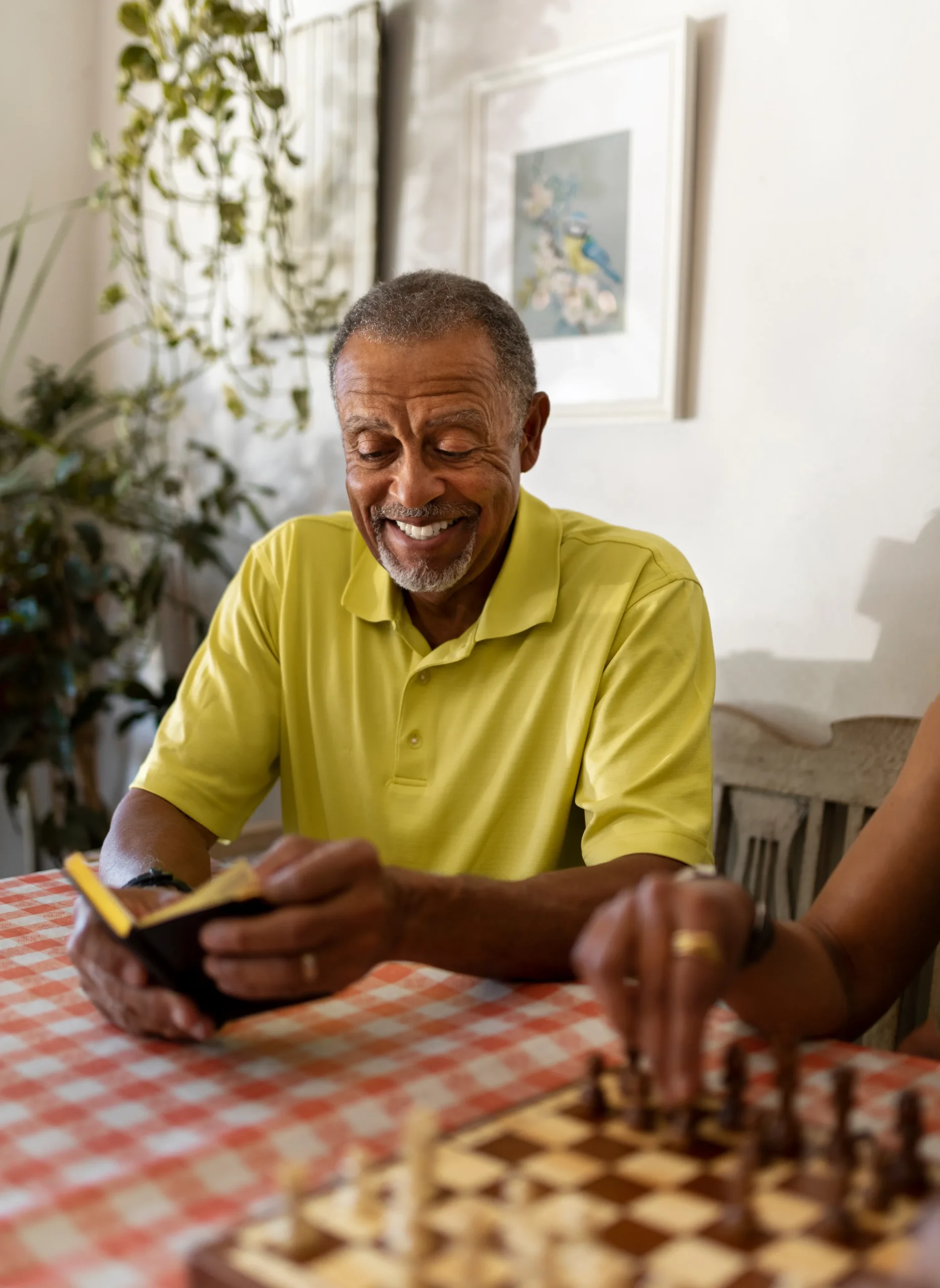Two seniors enjoying a game of chess indoors.