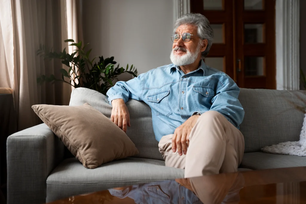 Senior man sitting comfortably on a couch.