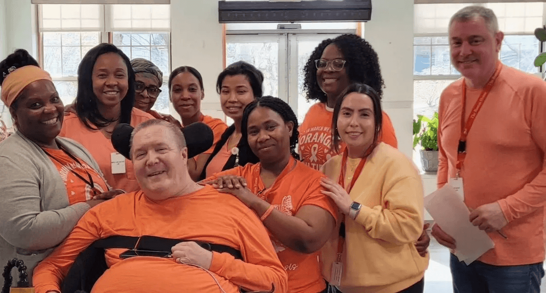 Group of staff and residents in orange shirts