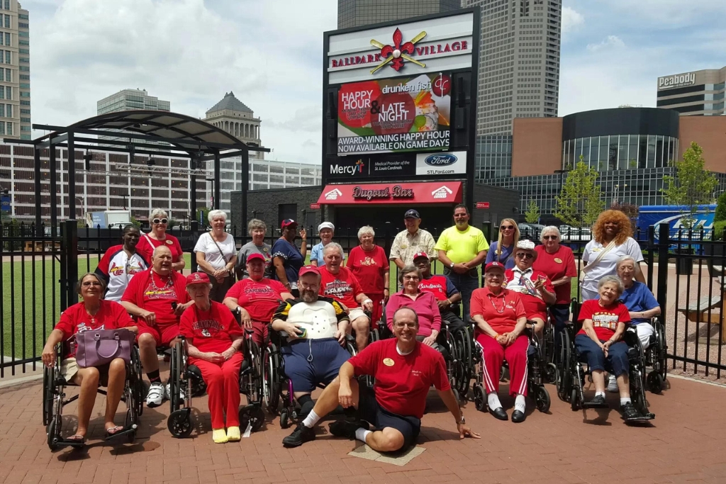 Residents and staff gathered outdoors in matching shirts.