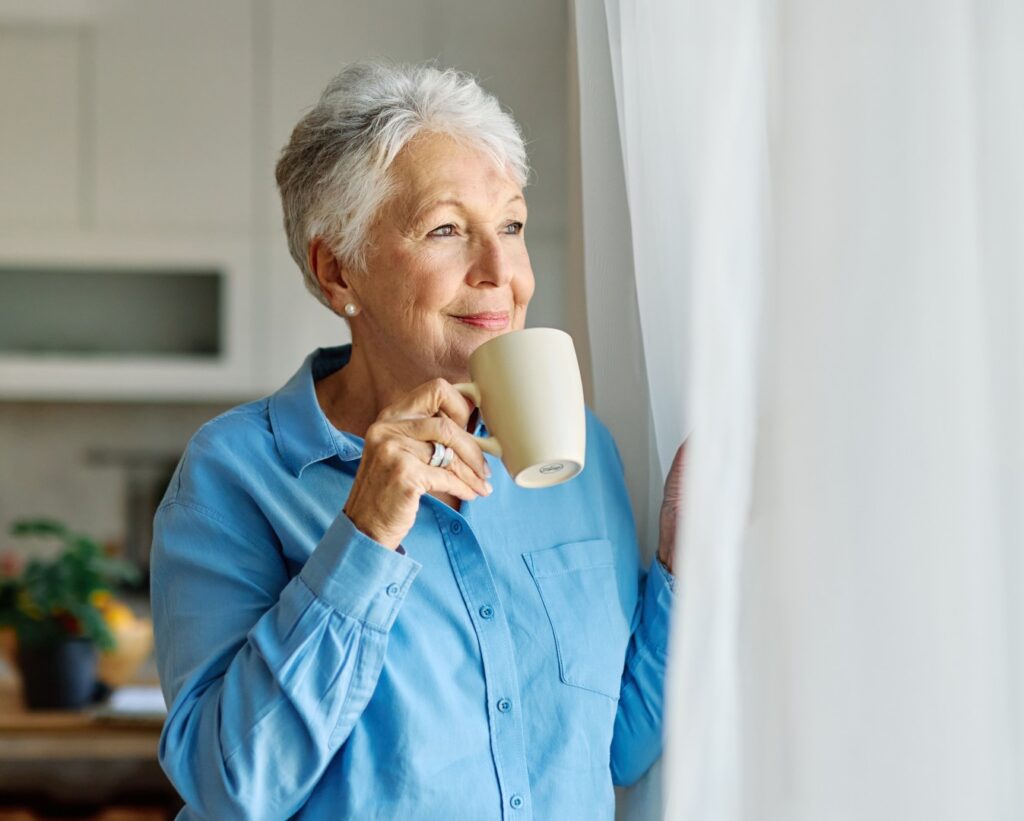Senior woman enjoying coffee by a window