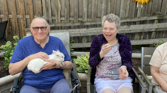 Residents enjoying outdoor activity with a rabbit.