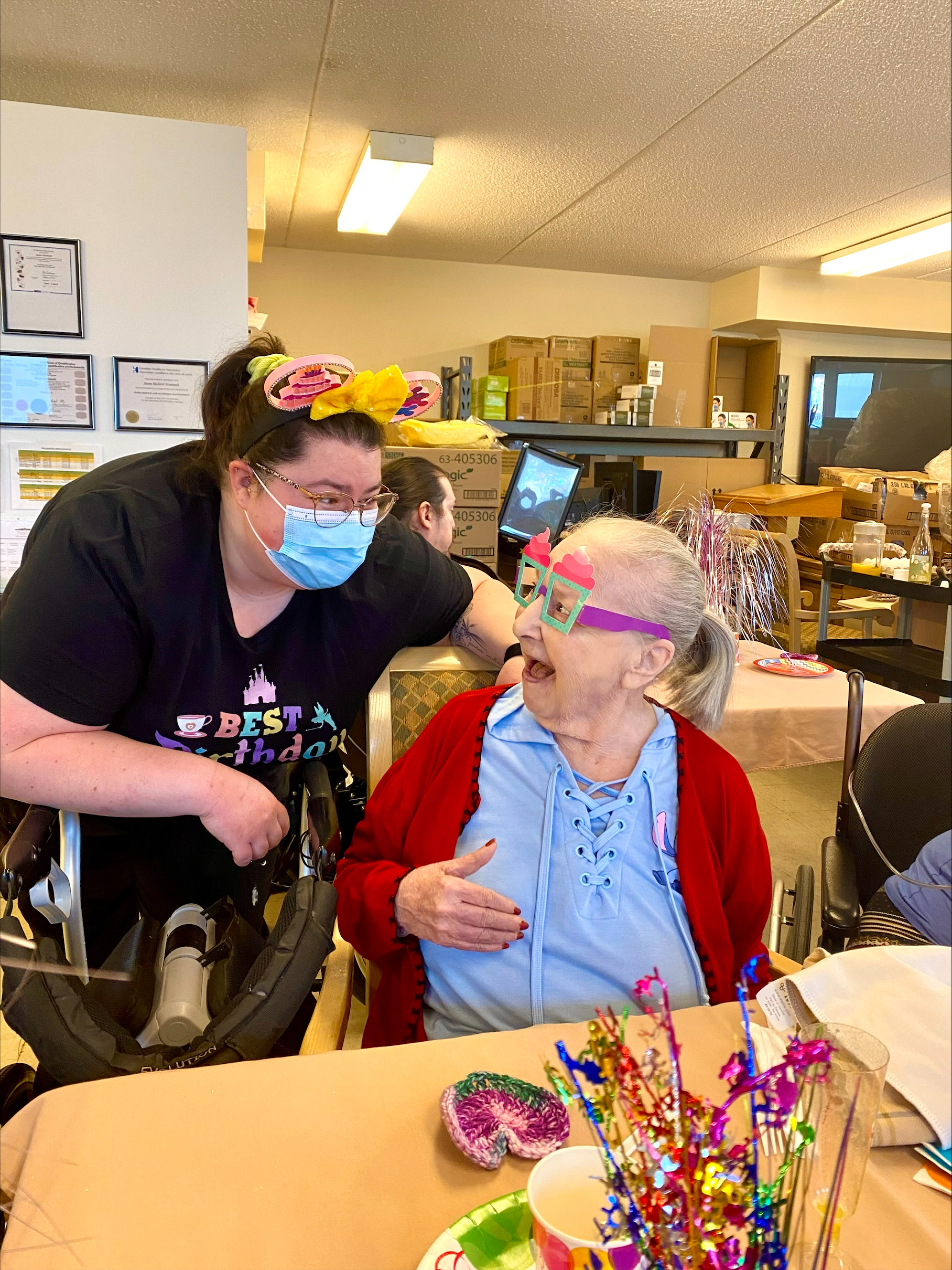 Staff member interacting with a resident at a birthday celebration.