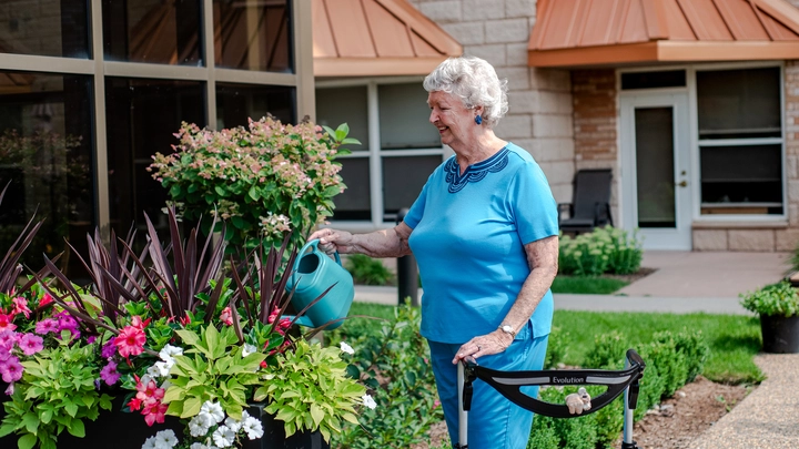 Senior woman watering flowers in garden
