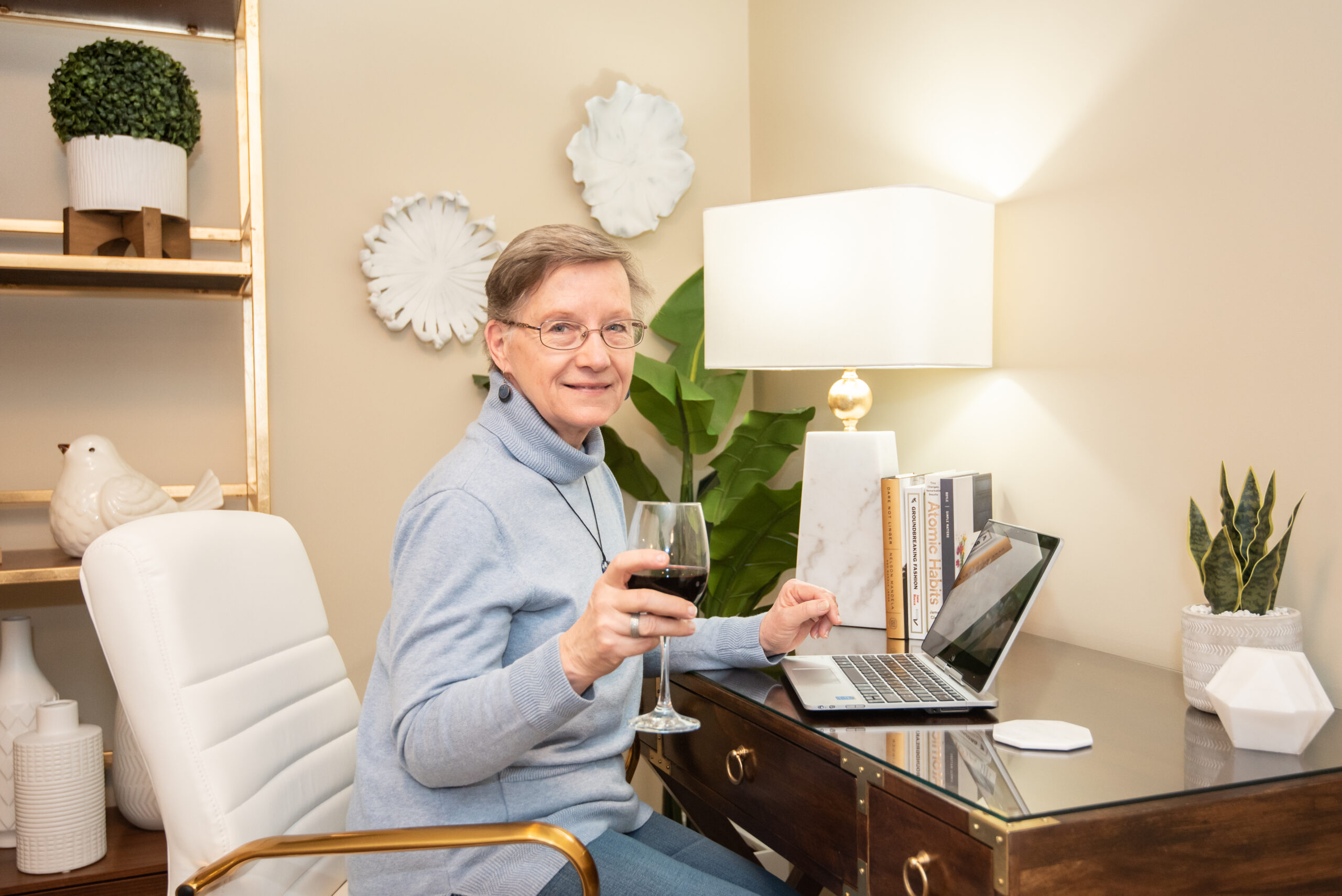 Smiling woman enjoying a drink at a desk