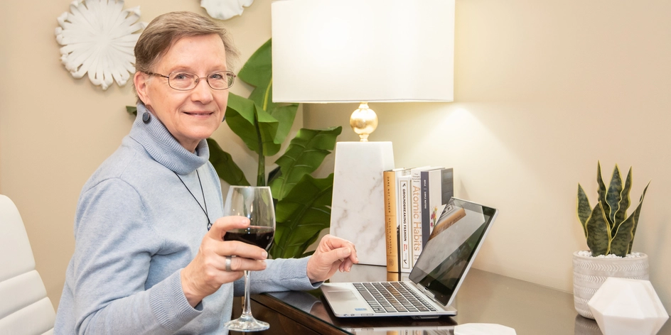 Senior woman enjoying a drink at her desk