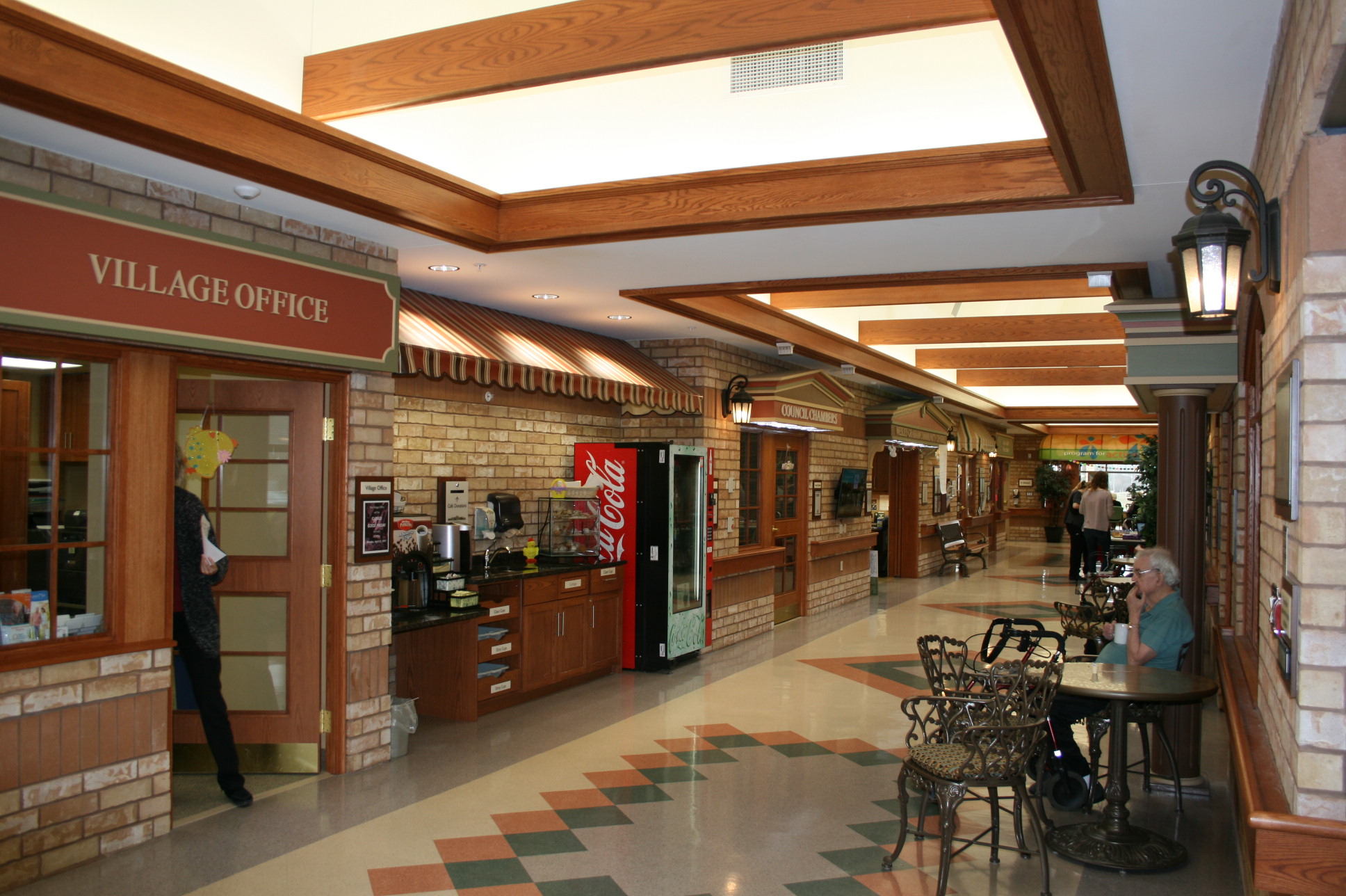 Interior view of a common area with residents and decor.