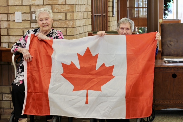 Two residents proudly holding a Canadian flag