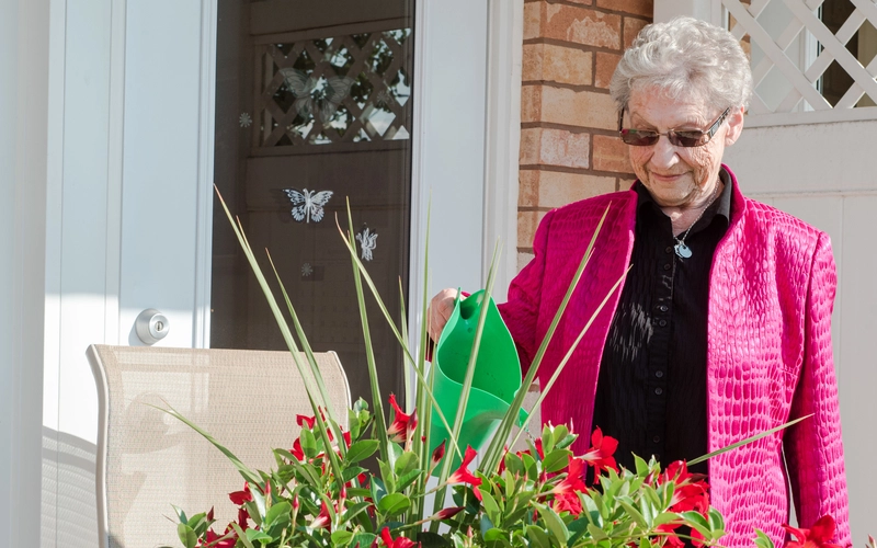 Resident watering flowers in an outdoor garden
