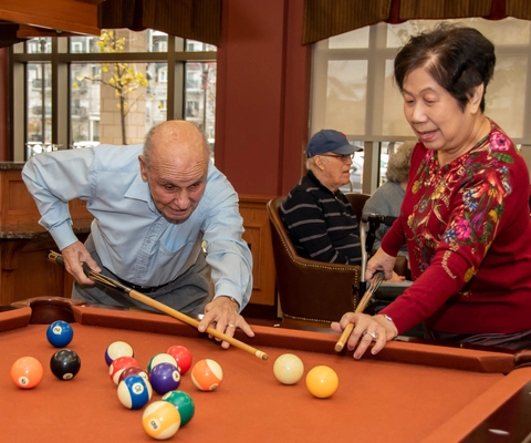 Residents playing pool in a common area