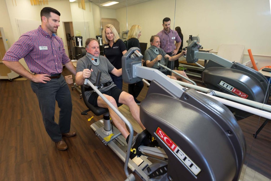 Residents engaging in fitness activities with staff assistance.
