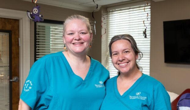 Two staff members smiling together in the facility