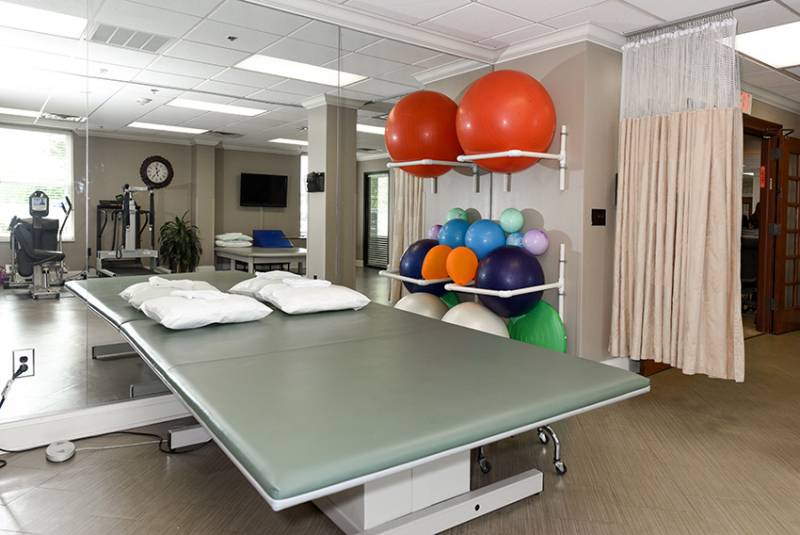 Rehabilitation space with therapy equipment and exercise balls.