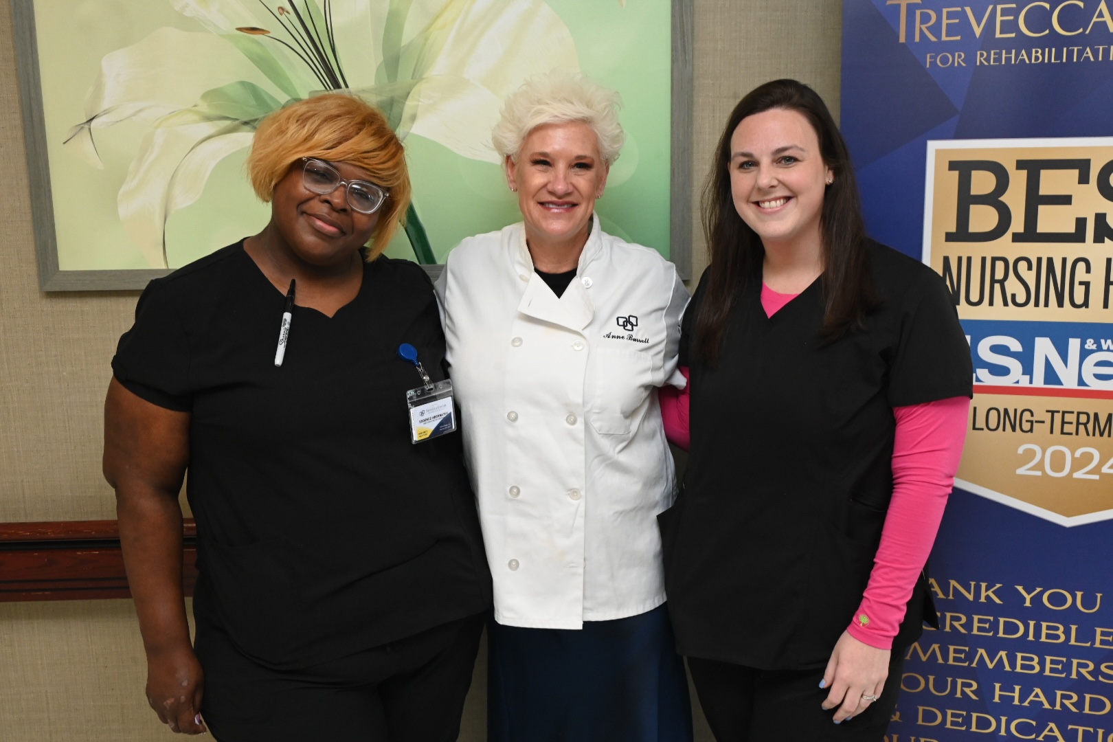 Three staff members posing together in a common area.