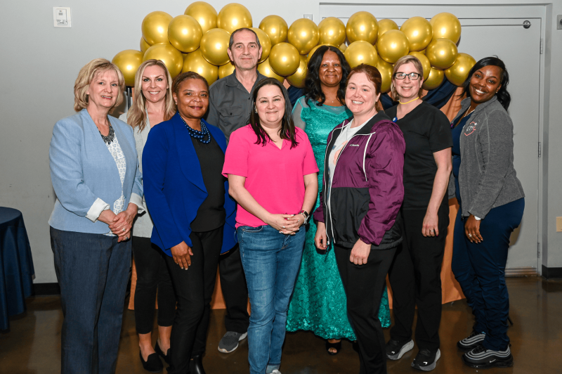 Group photo of staff posing together with decorations