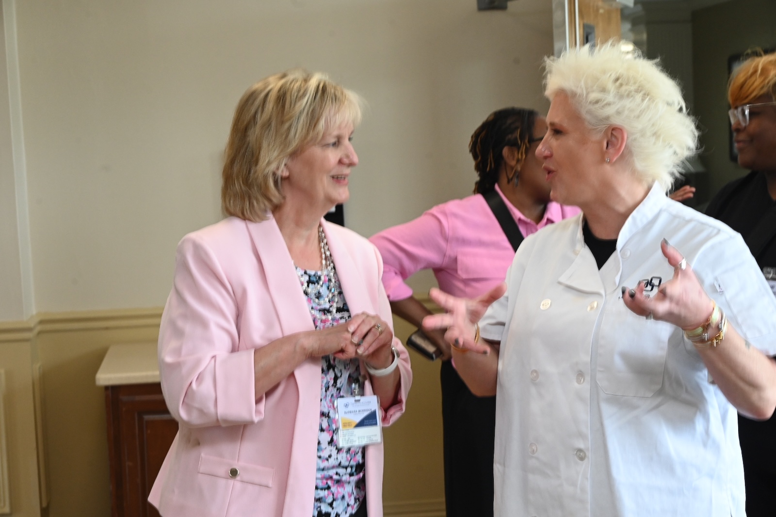 Two women engaged in conversation in a common area.