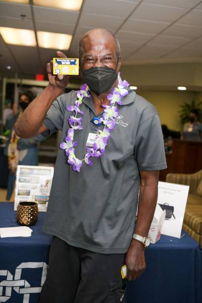 Staff member celebrating with a lei and card.