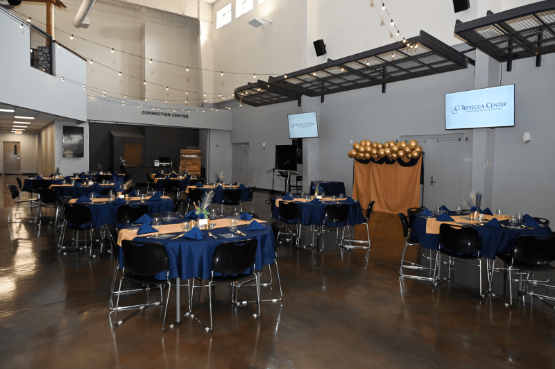 Dining setup in an event space with tables and decorations.