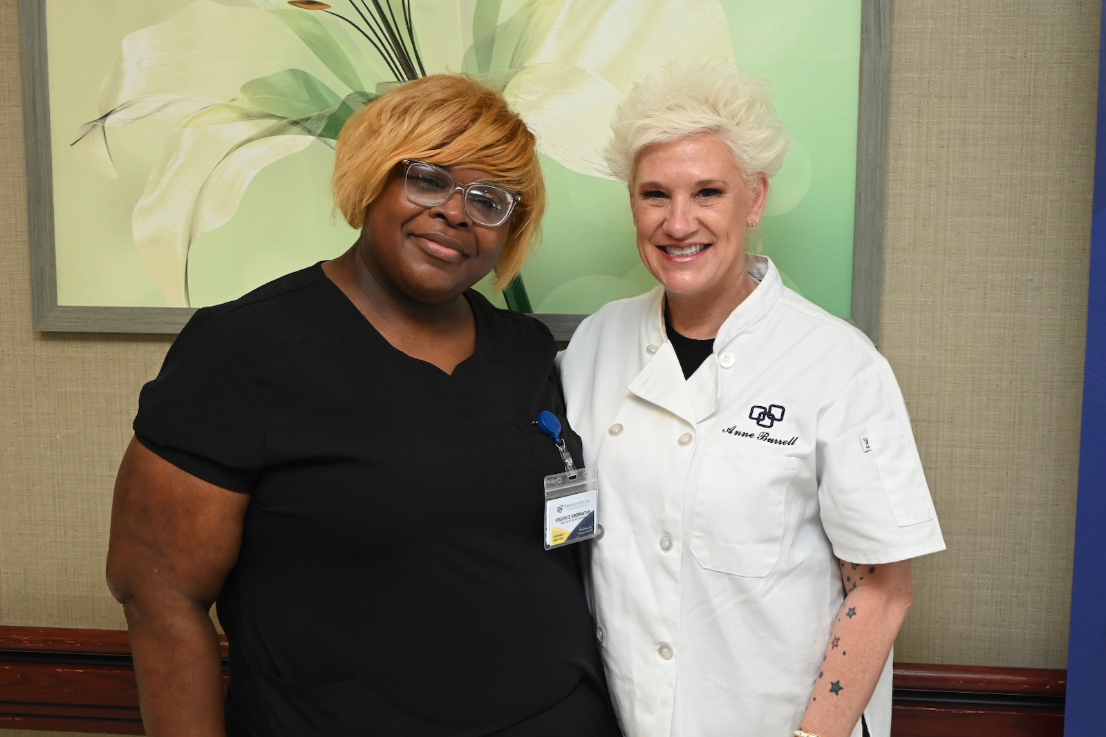 Two staff members smiling together indoors
