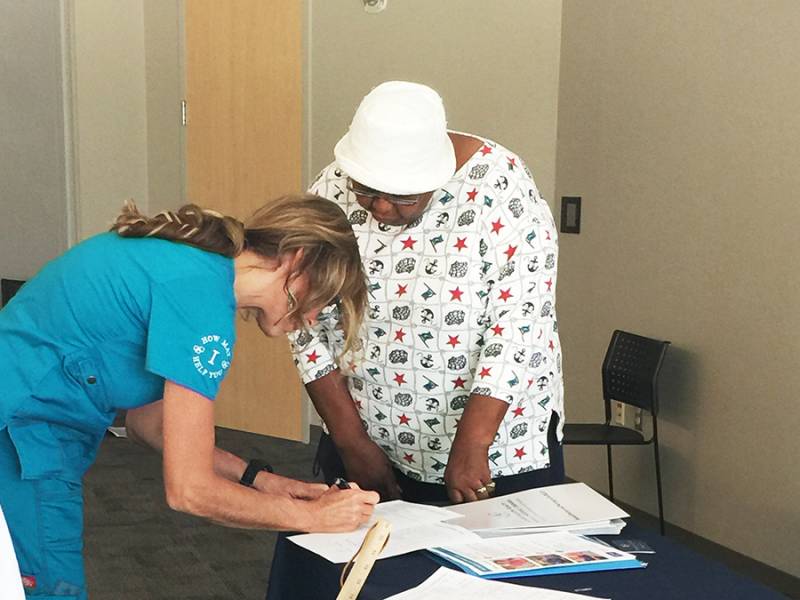 Staff assisting a resident with paperwork indoors