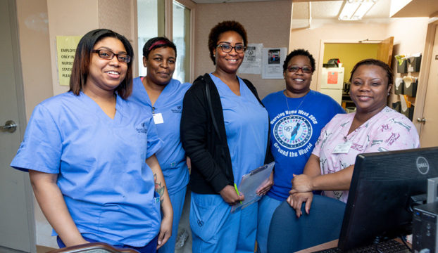 Staff members smiling at the reception desk.