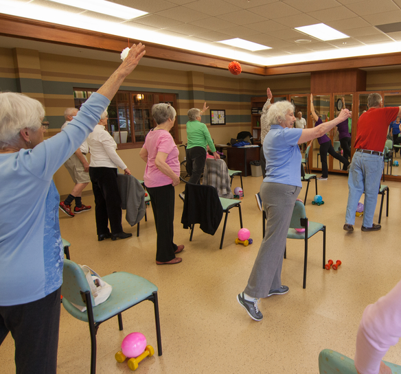 Residents engaged in a seated exercise class