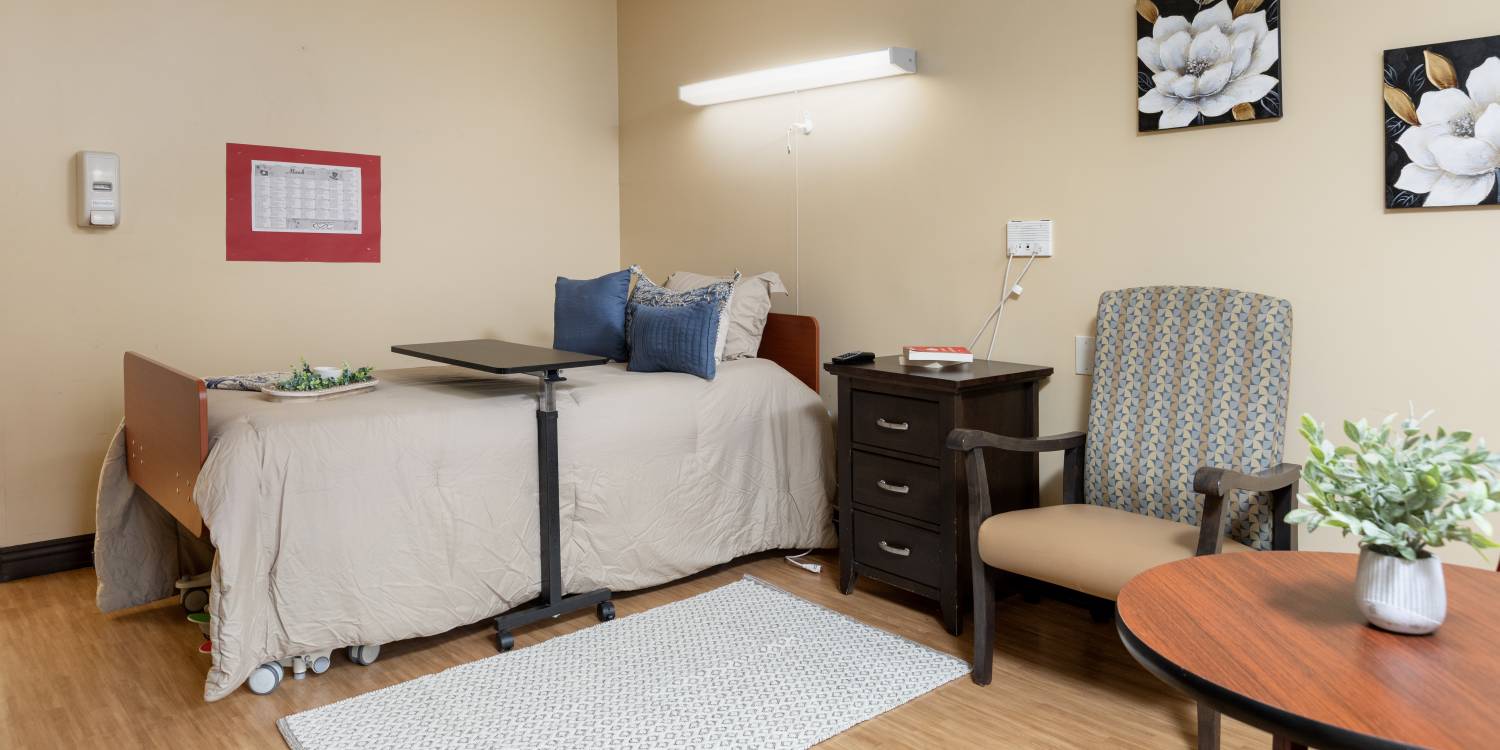 A private resident room with bed and chair
