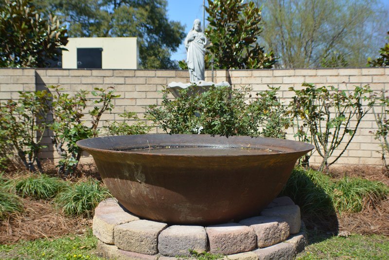 A fountain surrounded by greenery.