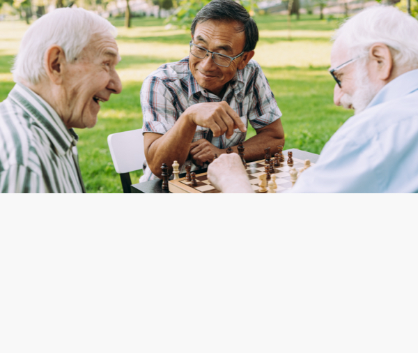Seniors enjoying a game of chess outdoors.